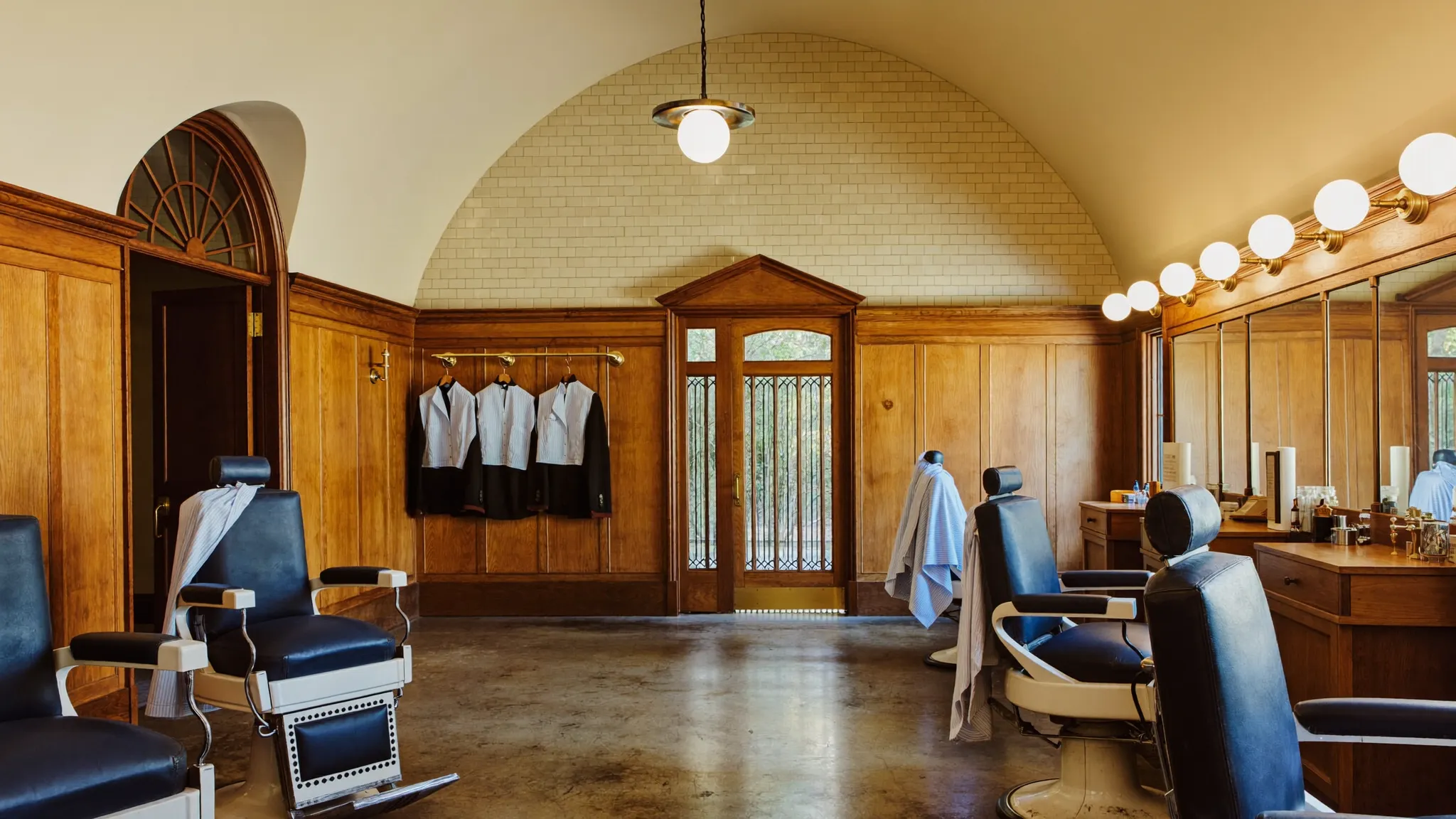 Inside Mr. Ellsworth's — vintage barber chairs beneath a tiled arch