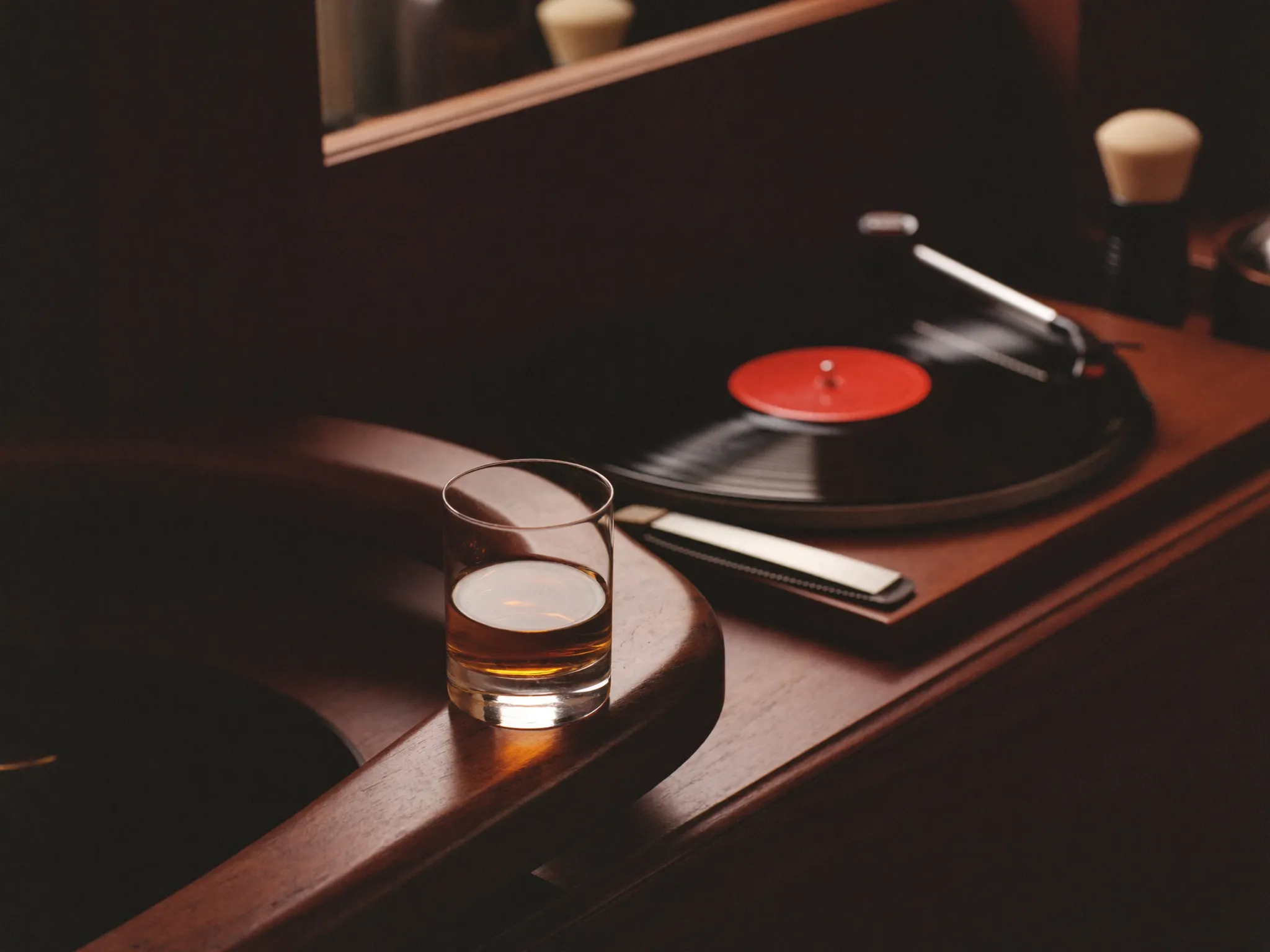 Bourbon and straight razor at a barber station, turntable behind